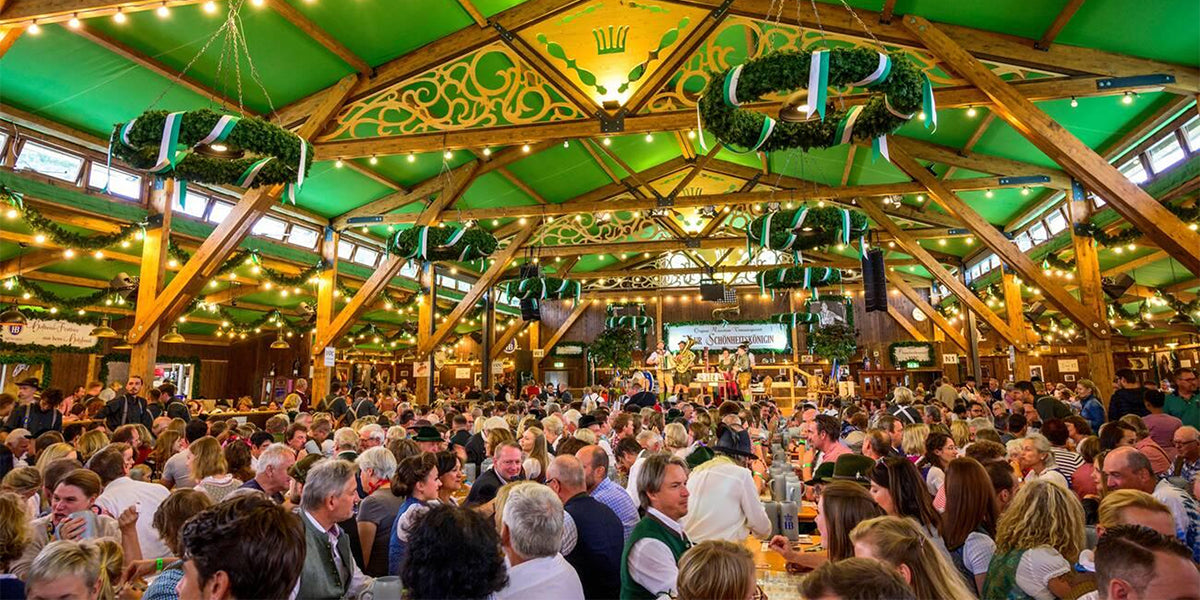 Crowded Oktoberfest beer tent with people drinking and socializing, showing common festival mistakes to avoid