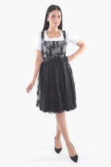 Elegant midi dirndl with a midnight black rose-patterned bodice, black lace apron, and white puff-sleeve blouse for Oktoberfest and Bavarian festivals