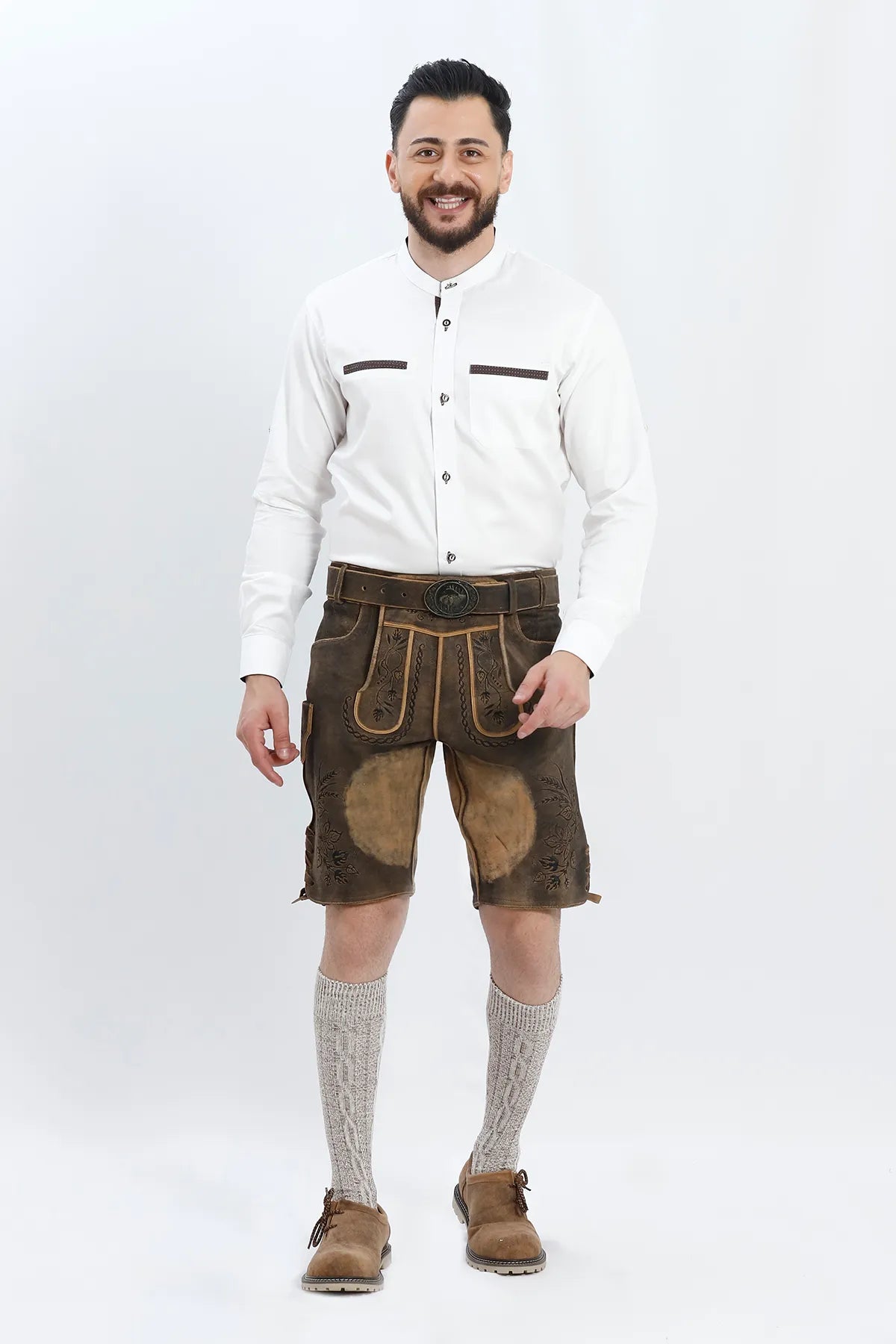 Lederhosen Men in Raw Black with Traditional Bavarian Embroidery. Model is wearing Traditional White Shirt, Bavarian Socks and Smoke Brown Lederhosen Shoes.